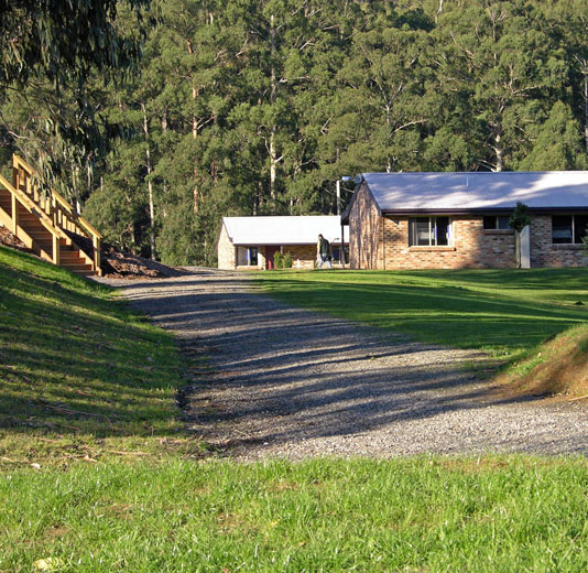 Image of Latrobe lodges, stone cottages with a grassy foreground