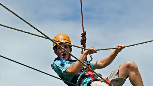 Man Hanging up high on the ropes